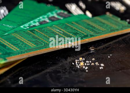 A stack of old SDRAM memory modules lying on a printed circuit board. Stock Photo