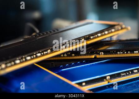 Four DDR memory chips in different colors lying on a blue printed circuit board. Stock Photo