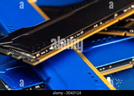 Four DDR memory chips in different colors lying on a blue printed circuit board. Stock Photo