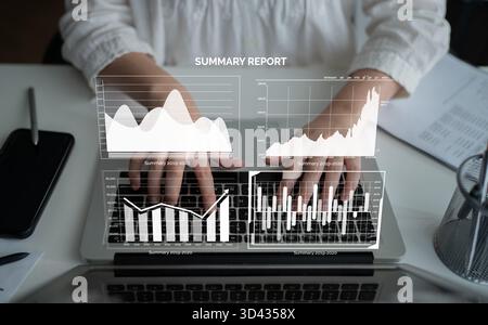 A business professional works on a laptop, engaging with detailed statistics and graphs in a modern office setting. The summary report reflects data Stock Photo