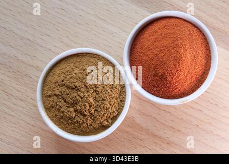 The paprika and cinnamon powder in a bowls on wooden table. Aromatic spices background. Stock Photo