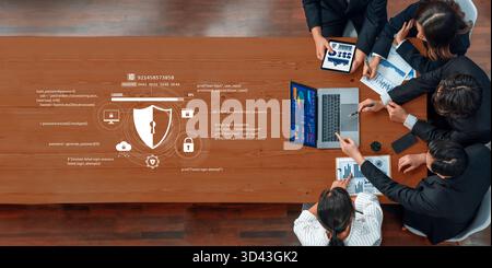 A group of focused business professionals collaborates on digital security strategies, analyzing data and discussing innovative solutions at a modern Stock Photo