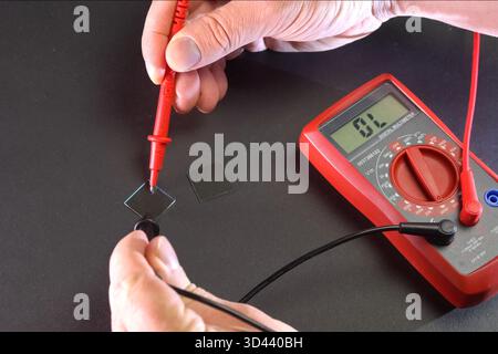 Measurement of product electrical parameters using a multimeter. Stock Photo