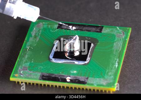 Application of liquid metal to the processor to install a cooling system. Stock Photo