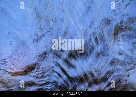 Shimmering blue water surface of a stream, current, light reflections, abstraction, long exposure, Sweden Stock Photo
