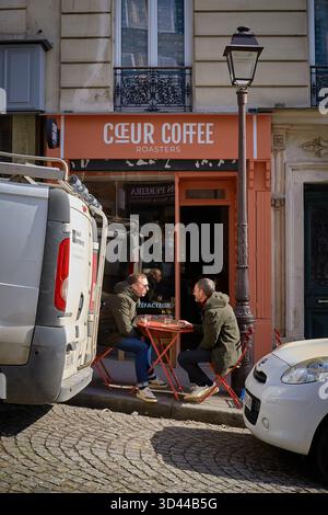 Friends enjoying coffee at a street cafe in Montmartre, Paris during a sunny day, Paris, France Stock Photo