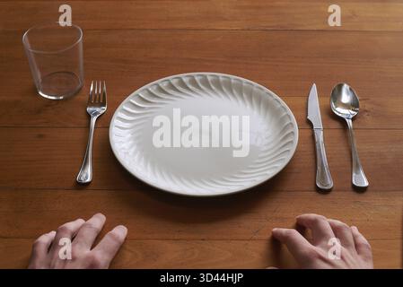 Point of view of a person about to eat on an empty porcelain plate Stock Photo