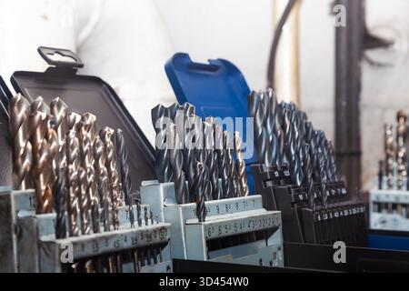 Sets of drills on a table in a workshop. Stock Photo