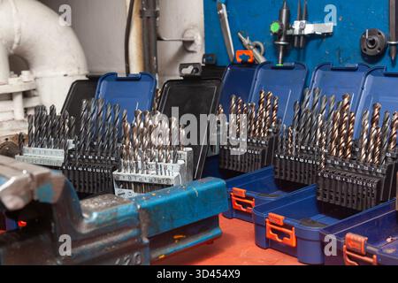 Sets of drills on a table in a workshop. Stock Photo
