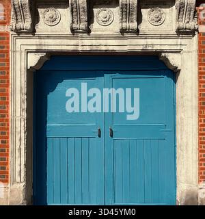 Blue gate set in red brick and limestone, blending urban geometry with the timeless architectural texture of Chicago Stock Photo