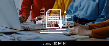 Diverse professionals engage in teamwork at a modern office, collaborating on project tasks with documents and laptop, focusing on data downloading Stock Photo