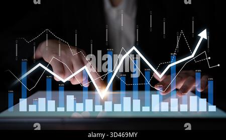 Professional business analytics image featuring a digital tablet displaying data trends and financial graphs, ideal for market analysis and financial Stock Photo