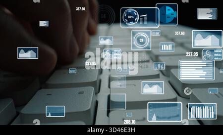 Close-up image of hands typing on a keyboard with digital data and analytics graphs surrounding it, showcasing a modern and dynamic workspace filled Stock Photo