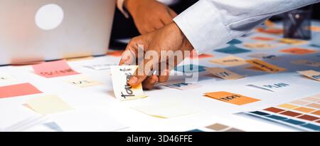A dynamic office scene showcases hands engaged in a brainstorming session, with colorful sticky notes spread across a table, reflecting creativity and Stock Photo