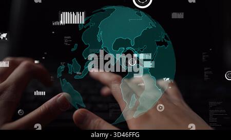 A close-up view of hands typing on a keyboard with a digital globe overlay. This image symbolizes global connectivity, data analytics, and the Stock Photo