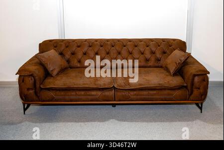Retro deep button tufting and traditional dark brown leather upholstery chesterfield sofa furniture Stock Photo