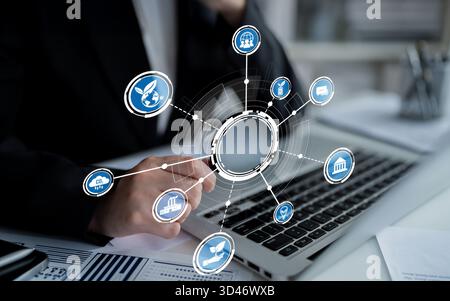 A business professional engages with a laptop in a modern office, surrounded by digital icons symbolizing various industries, highlighting Stock Photo