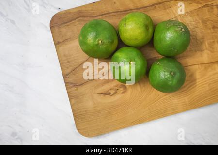Fresh Sweet Limes on wood. Healthy citrus fruits, Green Lime. Stock Photo