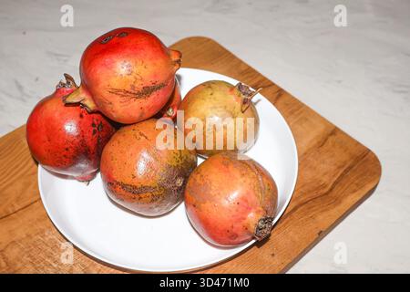 Fresh ripe pomegranate fruits on the wood. Punica granatum. Stock Photo
