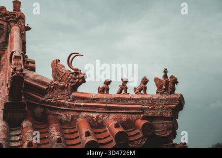Ornate roof details of traditional Chinese architecture in Beijing, China, showcasing intricate carvings and guardian figures. Stock Photo