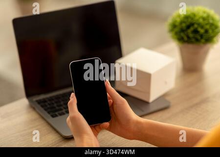Gadget Mockup for App Featuring Young Lady Holding Blank Smart Device in Workspace Setting Stock Photo