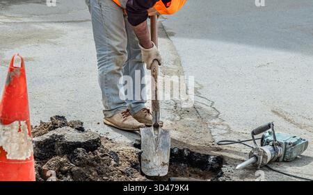 Utility workers on the street using special equipment. Plumbers prepares to fix the problem in the sewer. Repair work and maintenance outdoor street, Stock Photo
