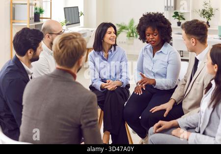 Diverse group of business professionals are discussing work projects during team building activity. Stock Photo