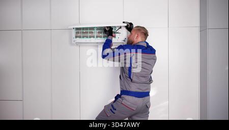 Professional AC Service Man Installing, Repairing, And Maintaining Air Conditioner. Stock Photo