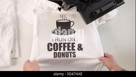 The Young Man Customizes T-shirts With His Heat Transfer Press. A Digital Designer Creates A Custom Logo Stock Photo