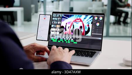 Man Using Mobile Software For Editing Videos On Laptop Track Time Stock Photo