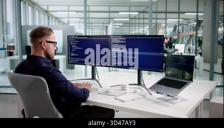 Young Programmer Man Coding Software On Desktop Computer At Office. Stock Photo