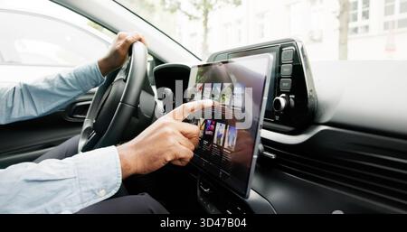 Black Man Driving Car With Modern Touchscreen Infotainment System. Stock Photo