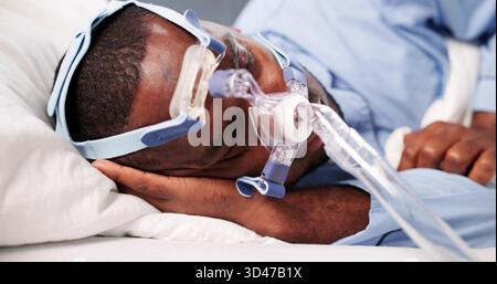 Man Using CPAP Mask For Sleep Apnea Therapy In Bed Stock Photo