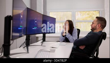 Tech Manager Coaching Young Male And Female On Software Update Stock Photo