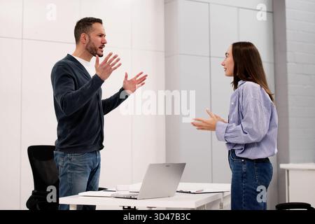 Office Conflict: Man And Woman Argue, Shouting Argument Between Professionals Stock Photo