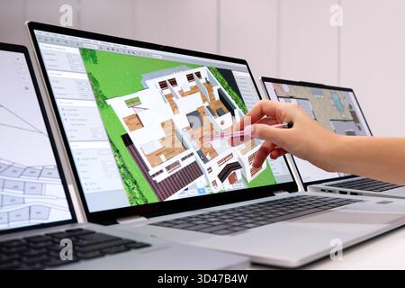 Young Male Engineer Using 3D CAD Software For House Design Stock Photo