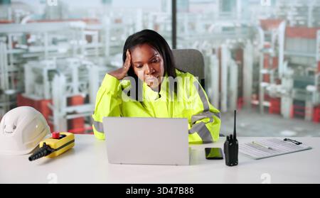 Troubled African-American Engineer Repairs Broken Software At Oil Refinery Factory. Stock Photo
