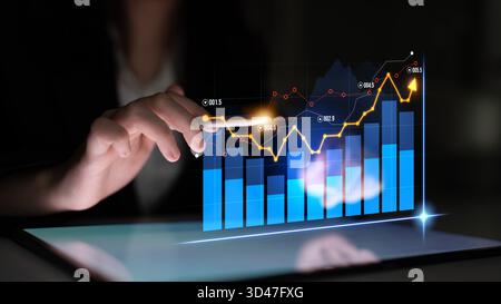 A businesswoman interacts with a digital tablet displaying dynamic market data visualizations, showcasing trends and analysis in a modern office Stock Photo