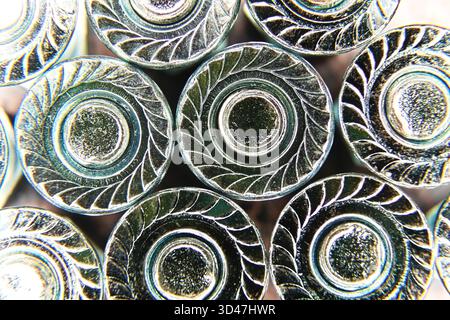 Rows of nuts with inserted bolts are arranged closely, showcasing detailed engravings on the metallic surface. Stock Photo