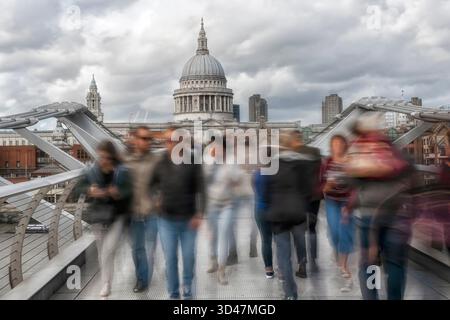 People in motion on Millennium Footbridge with St Paul's Cathedral in the background Stock Photo
