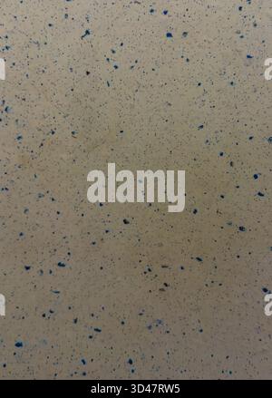 Abstract beige surface with scattered blue specks and grainy texture Stock Photo