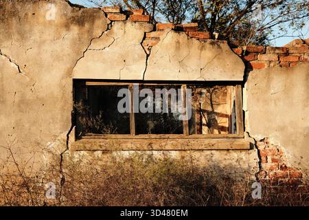 Cracked wall and broken window of abandoned building Stock Photo