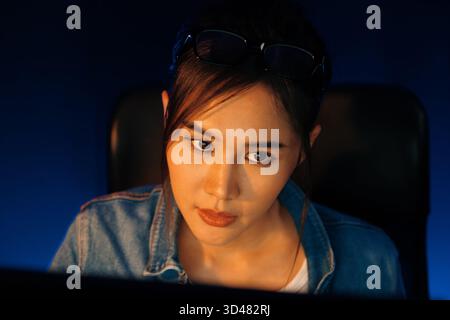 Portrait young beautiful Asian creative with serious face looking on pc to search project creator social media online, planning new strategy creator Stock Photo