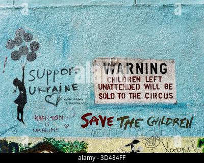 Graffiti on a blue wall in Amsterdam. Warning children left unattended will be sold to the circus Stock Photo