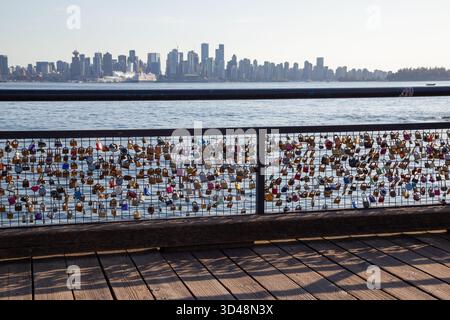 Love Locks locked on the railing with Vancouver skyline background at Lonsdale Quay Market in North Vancouver, British Columbia, Canada. Stock Photo