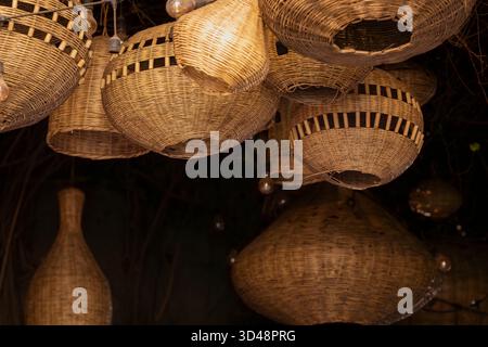 Handwoven wicker baskets and lamps displayed in a traditional Moroccan market stall. Rustic assortment of woven baskets hanging in a souk, showcasing. Stock Photo