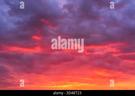 Glowing sky at sunset texture background overlay. Dramatic red, orange, and purple clouds. High resolution photography perfect for sky replacement Stock Photo