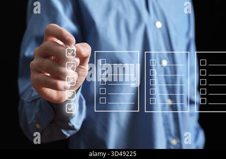Person's hand marking check boxes on an interactive screen, completing a survey or project management task list Stock Photo
