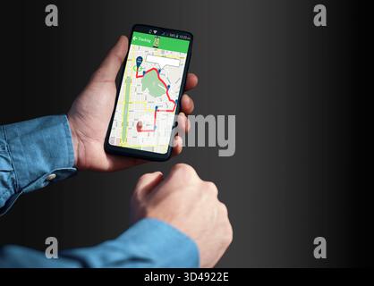Hands holding phone displaying a real-time tracking map with a red route and location pins, indicating navigation, location tracking or delivery Stock Photo