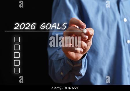 Hand of a man writing out a list of 2026 goals, concept for future planning and resolution Stock Photo